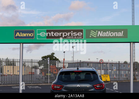 Alamo, Enterprise et signes nationaux à un dépôt de location de voiture - Location de voiture de l'aéroport de Manchester, UK Village Banque D'Images