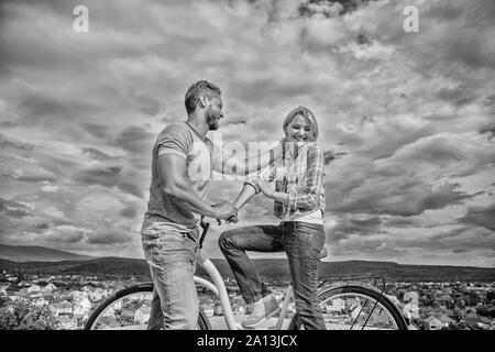 Homme avec barbe et dame blonde timide sur la première date. Comment satisfaire les filles alors qu'à vélo. Ramasser des fille. Couple tout juste de faire connaissance. Femme se sent timide en société avec macho attrayant. Banque D'Images
