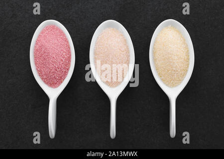 Rouge, orange et jaune instant jelly jello ou en poudre sur les petites cuillères, photographiés sur ardoise frais généraux Banque D'Images