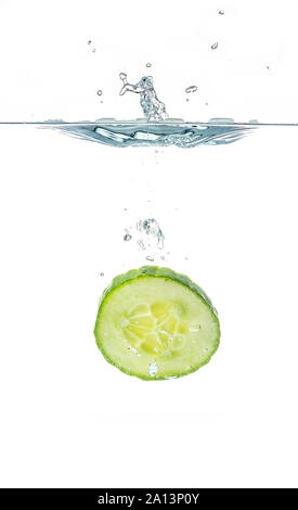 Tranches de concombre frais dans l'eau isolé sur fond blanc. Une coupe Banque D'Images
