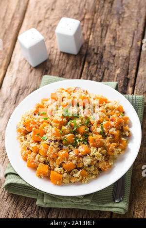 Végétalien maison citrouille cuite au four, le chou-fleur et salade d'oignons rouges ou un plat garni de persil frais haché et servi sur la plaque Banque D'Images
