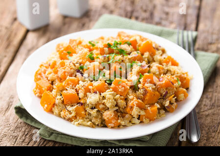 Végétalien maison citrouille cuite au four, le chou-fleur et salade d'oignons rouges ou un plat garni de persil frais haché et servi sur la plaque Banque D'Images