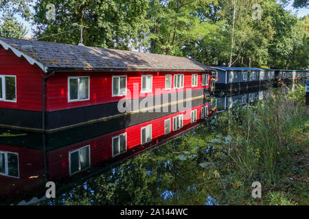 Péniche rouge amarré en permanence sur les rives de la Basingstoke Canal dans la région de Pampigny Woking, Surrey, Angleterre du Sud-Est, Royaume-Uni Banque D'Images