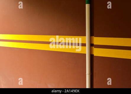 Lignes jaunes peints sur le mur brun dans l'aire de stationnement, le jaune est la couleur la plus visible de loin. Cela peut réduire les dommages causés par l'impact de voiture Banque D'Images