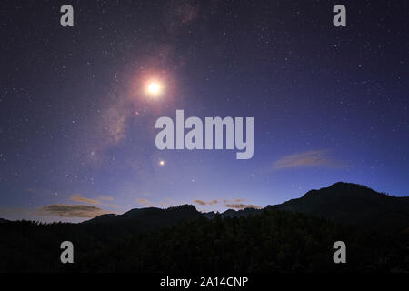 La Voie Lactée et lune croissante briller au-dessus de la montagne à Pai, au nord de la Thaïlande. Banque D'Images