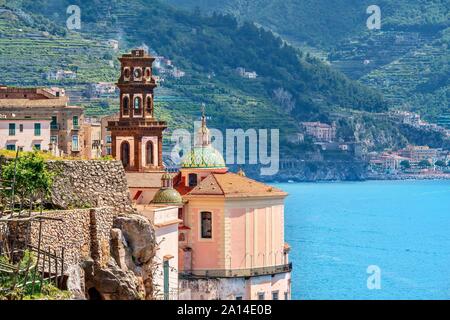 Le brown Bell Tower, dômes, et rose de extérieur arrière de l'église de Sainte Marie Madeleine, à Atrani, Italie, sur la côte amalfitaine. Banque D'Images