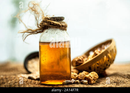 Organique de kharek ou dattes séchées dans un panier ou un panier avec ses extraits de plantes médicinales de l'huile bénéfique dans une bouteille transparente sur le sac de jute su Banque D'Images