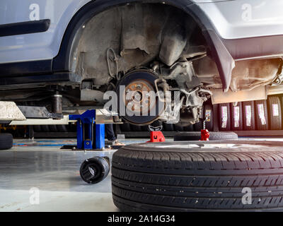 Volant en attente de changer de pneus sur les automobiles à levée auto service garage. Banque D'Images