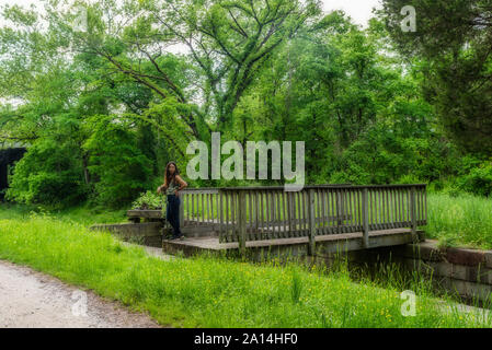 Femme debout sur le pont au-dessus du verrou sur Chesapeake and Ohio Canal Banque D'Images