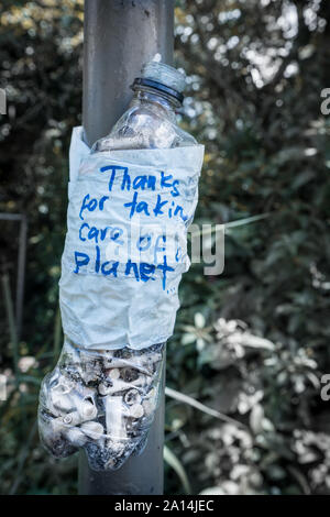 Bouteille en plastique avec un message "Merci de prendre soin de notre planète" rempli de mégots de cigarettes. Idée d'empêcher la pollution de l'environnement. Banque D'Images