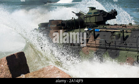 Les Marines américains conduire un véhicule amphibie d'assaut de la terre dans l'eau. Banque D'Images