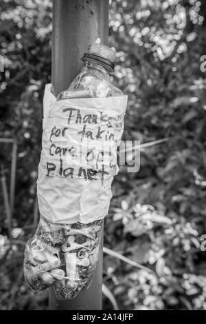 Bouteille en plastique avec un message "Merci de prendre soin de notre planète" rempli de mégots de cigarettes. Idée d'empêcher la pollution de l'environnement. Banque D'Images