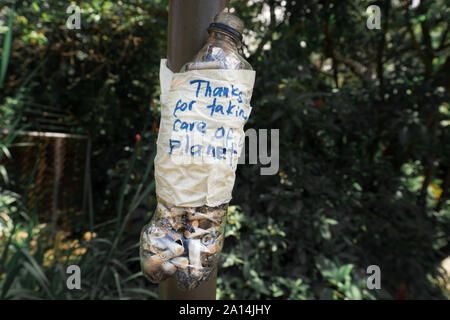 Bouteille en plastique avec un message "Merci de prendre soin de notre planète" rempli de mégots de cigarettes. Idée d'empêcher la pollution de l'environnement. Banque D'Images