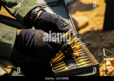 Un technicien des explosifs et munitions de calibre .50 étape se prépare à tours. Banque D'Images