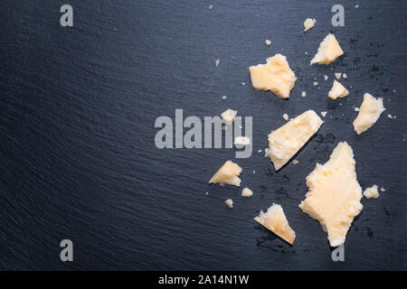 Vue de dessus de fromage parmigiano frais savoureux morceaux sur fond d'ardoise noire, copy space Banque D'Images