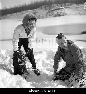 L'hiver dans les années 40. Acteur Nils Kihlberg, 1915-1965 est photographié ici avec son épouse Ann-Britt. Ils sont tous deux portant des vêtements d'hiver et joue dans la neige en riant. Suède 1943. Kristoffersson Ref D71-1 Banque D'Images