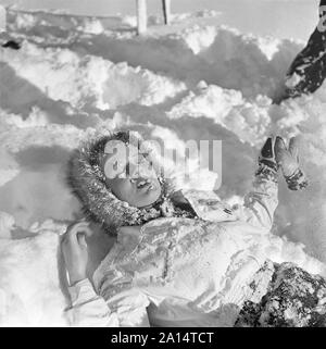 L'hiver dans les années 40. Une jeune femme est couché dans la neige. Suède 1943. Kristoffersson Ref D70-3 Banque D'Images