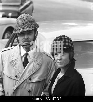 La conduite dans les années 1960. Location de casques bleus a été introduit en Suède à encrease sécurité personnelle lors de la conduite automobile. Les fabricants de casques l'espère les ventes d'entre eux serait accéléré par le changement à venir de la conduite sur le côté gauche sur la route, à droite. Assez curieusement moins d'accidents s'est produit avant le changement. alors Sur la photo, un jeune couple portant leurs casques qui ont été faites de manière différente pour les hommes et les femmes. La Suède 1966 ref CV38-2 Banque D'Images