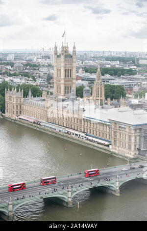 Vue aérienne du parlement britannique (vu du London Eye), et trois rouges Double-Decker bus traversant le pont de Westminster, sur la Tamise.. Banque D'Images