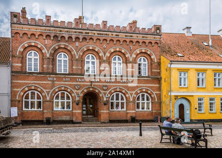 Deux hommes assis sur un banc en face de la mairie dans AErøskøbing, Danemark, le 13 juillet 2019 Banque D'Images