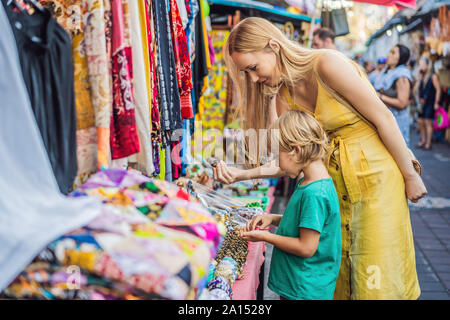 Mère et fils voyageurs de choisir des souvenirs dans le marché à Ubud à Bali, Indonésie Banque D'Images