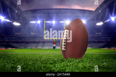 Ballon de football américain dans le stade de nuit sous les projecteurs Banque D'Images