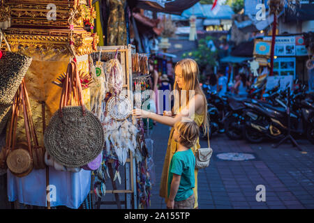 Mère et fils voyageurs de choisir des souvenirs dans le marché à Ubud à Bali, Indonésie Banque D'Images