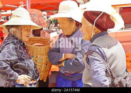 Les groupes ethniques locaux de personnes vendre et acheter des produits au marché aux puces Vendredi à Shaxi village de l'ancienne route de commerce de chevaux et de thé dans le Yunnan, en Chine. Banque D'Images