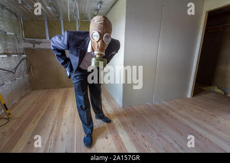 Homme étrange en costume d'affaires et de gaz à l'intérieur d'un masque de protection prix en rénovation travaux publics. Banque D'Images