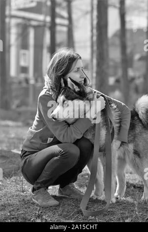 Portrait noir et blanc d'une femme triste de dire au revoir à son chien de traîneau husky animal Banque D'Images