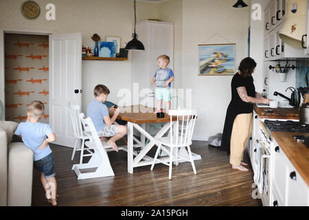 Maman avec ses trois fils dans la cuisine Banque D'Images