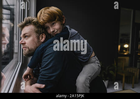 Père et fils traîner à la maison le jour de pluie Banque D'Images