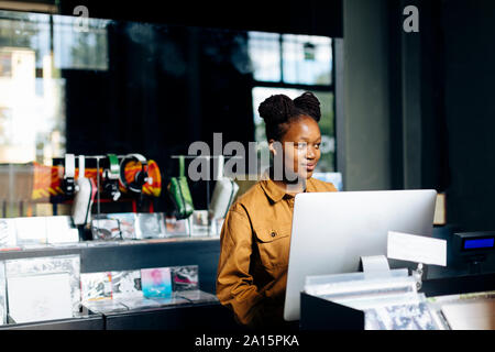 Jeune femme travaillant dans un magasin de disques Banque D'Images