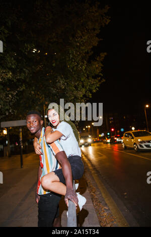 Happy young couple sur la rue la nuit dans la ville Banque D'Images