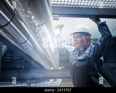 Artisane wearing hard hat travaillant au niveau du Banque D'Images