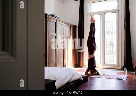 Jeune brunette woman practicing yoga in chambres d'étudiants Banque D'Images