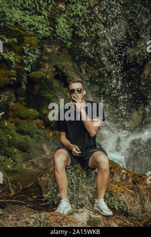 Portrait d'un jeune homme dans une chute de fumer un joint de marijuana Banque D'Images