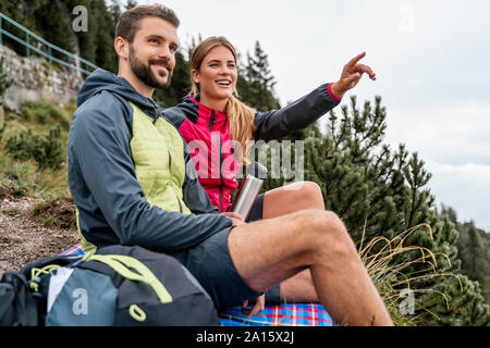 Happy young couple en randonnée dans les montagnes d'avoir une pause, Italia, Bavière, Allemagne Banque D'Images