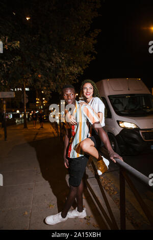 Happy young couple sur la rue la nuit dans la ville Banque D'Images