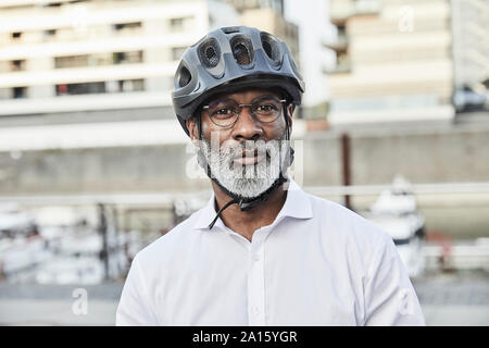 Portrait of mature businessman avec barbe grise portant des lunettes et casque de vélo Banque D'Images