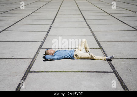 Jeune homme allongé sur un carré Banque D'Images