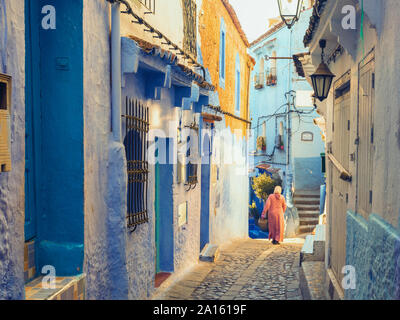 Femme marche dans la vieille ville de Chefchaouen avec le célèbre blue bâtiments, Chefchaouen, Maroc Banque D'Images