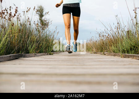 Female jogger running on allée en bois Banque D'Images