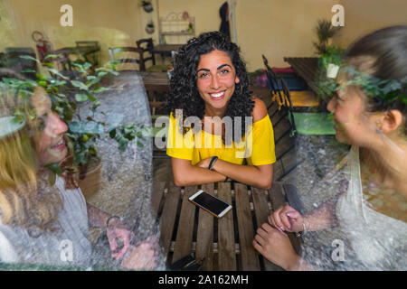 Portrait de jeune femme avec des amis dans un bistro Banque D'Images