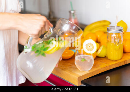 Close-up of woman in kitchen à verser dans un verre de limonade Banque D'Images