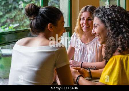 Trois professionnels réunion des jeunes filles dans un café Banque D'Images