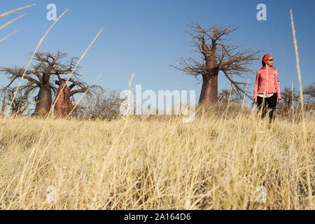 Femme avec les baobabs en arrière-plan, Makgadikgadi Pans, Botswana Banque D'Images