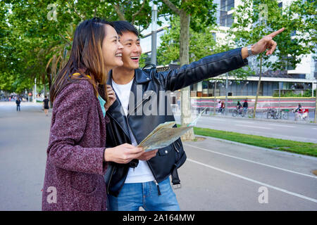 Couple de touristes visitant la ville et en maintenant une carte, Barcelone, Espagne Banque D'Images