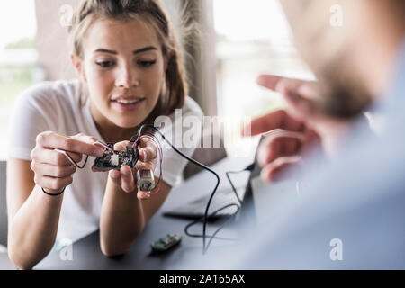 Jeune femme et l'homme travaillant sur l'équipement informatique in office Banque D'Images