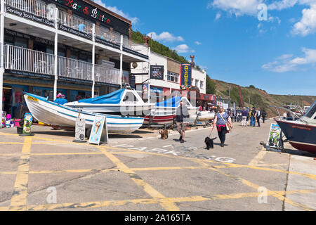 Dh Coble landing FILEY YORKSHIRE DU NORD Personnes couple walking dogs bateaux Banque D'Images